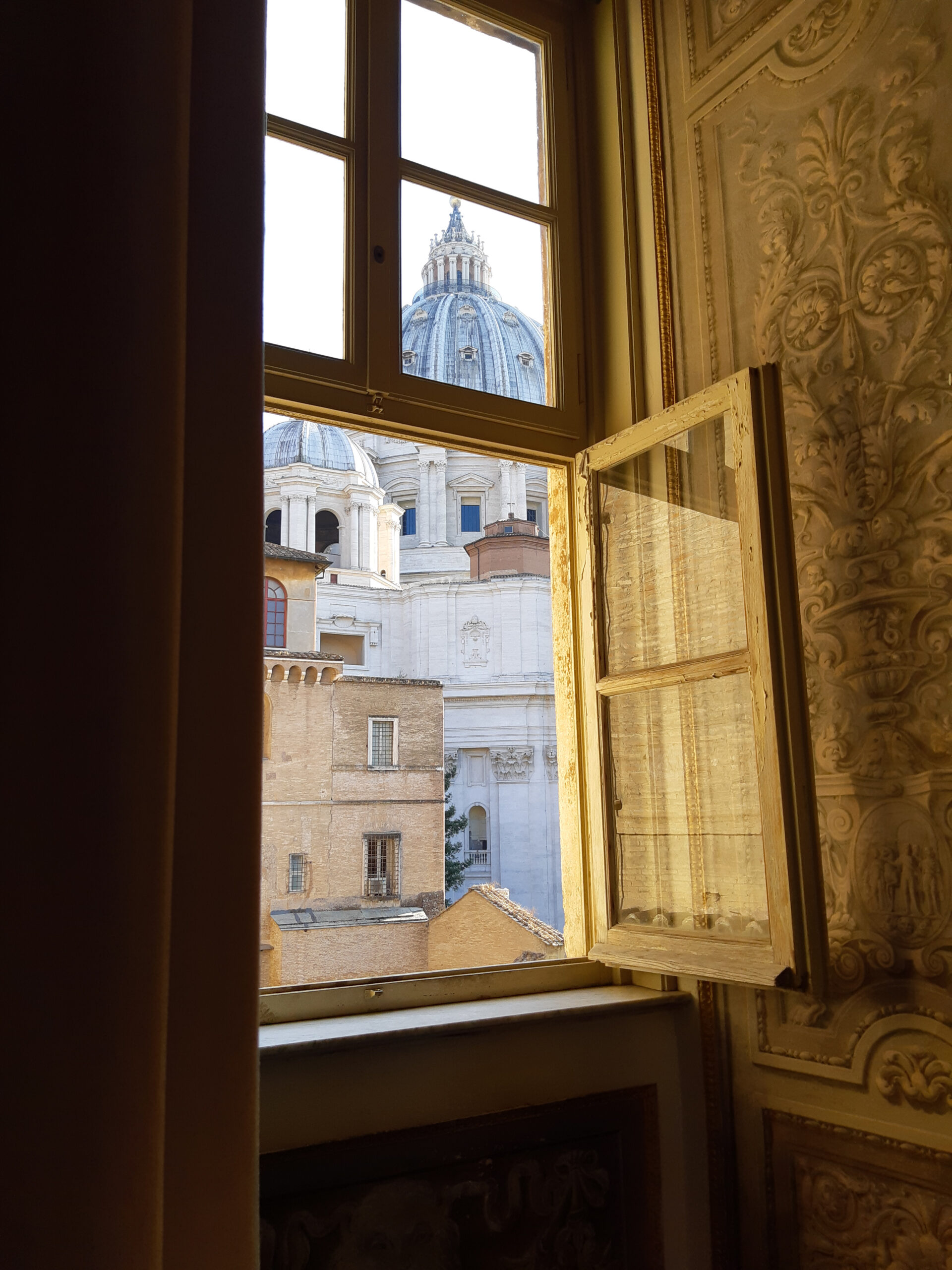 Widok przez okno na Bazylikę św. Piotra w jednej z sal w Muzeach Watykańskich